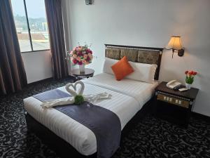 关丹Go Lodge Hotel Kuantan的酒店客房,配有一张带弓的床铺