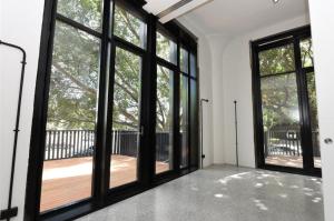 悉尼WRIGLEY'S GUM FACTORY LUXURY CONVERSION的空房设有大窗户和木甲板