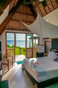 纳玛塔库拉芒果湾度假村的一间卧室配有一张床,享有海景
