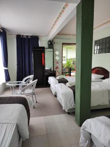 停泊岛Perhentian Chomel Chalet的一间设有四张床和一张桌子及椅子的房间