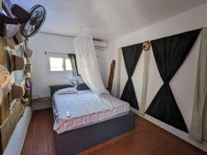 NdanganeLa Maison Blanche的一间卧室配有一张带蚊帐的床