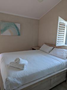 拜伦湾拜伦湾海滨公寓的一间卧室配有一张床,床上有毛巾