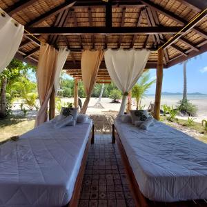 La Tranquilidad Beach Club的海滩景凉亭内的两张床
