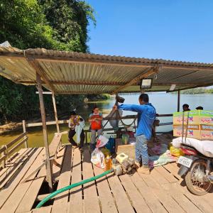 邦隆Banlung Mountain View Treks & Tours的一群人站在码头的屋顶下