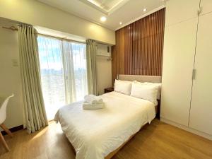 马尼拉mushROOM Condotel at Infina Towers, Quezon City的一间卧室配有一张床,上面有两条毛巾