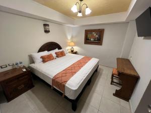 梅里达Hotel Casablanca 160的一间卧室配有一张大床和一张桌子