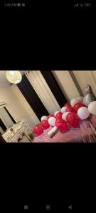 安曼اوليفيا للشقق الفندقية的床上的一大堆红白气球