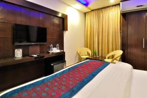 新德里谢尔顿酒店 的配有一张床和一台平面电视的酒店客房
