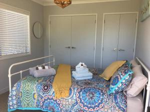 卡蒂卡蒂Kaimai Range Country Getaway的一间卧室配有带毛巾的床