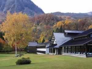 小坂十和田王子酒店的一座有树木和山脉的建筑
