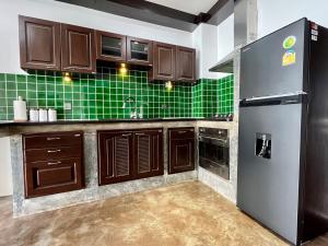 涛岛Ocean Front Apartments的厨房配有棕色橱柜和绿色瓷砖