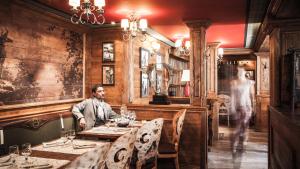 瓦勒迪泽尔阿尔蒂图德酒店的坐在餐厅桌子上的男人