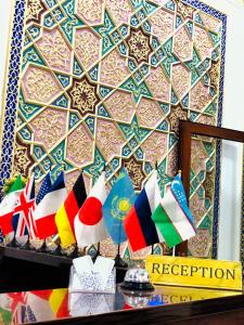 布哈拉Jahangir Boutique Bukhara的架子上挂着不同旗帜的墙壁的房间