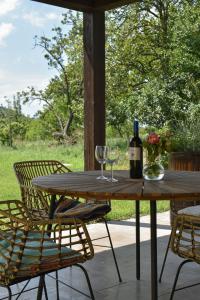 维帕瓦Small house in Vipava valley的一张带两杯酒和一瓶葡萄酒的木桌