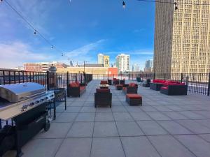 芝加哥McCormick Place Skyline view 2br-2ba with Optional parking for 6 guests的一个带桌椅和烧烤设施的屋顶露台