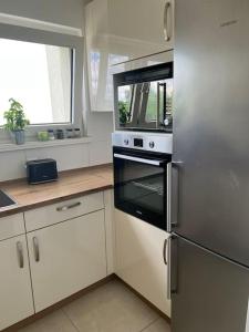 杜伊斯堡Schöne Wohnung Nähe Düsseldorf Messe und Flughafen的厨房配有不锈钢冰箱和白色橱柜