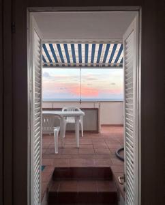 圣凯撒利亚温泉Casa con terrazza vista 180° sulla costa orientale的天井的门上设有桌子,享有美景。