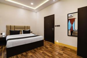 加尔各答OYO Hotel sakina的铺有木地板的客房内设有一间卧室和一张床。