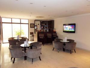 拉各斯S & S Hotel & Suites的餐厅设有桌椅和平面电视。