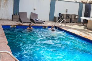 拉各斯S & S Hotel & Suites的游泳池里的男人和孩子