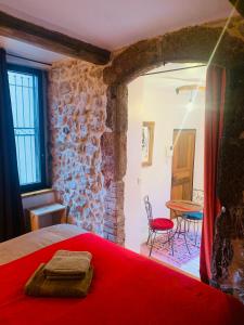 昂迪兹Le monde de Théodore的一间卧室配有红色的床和桌椅