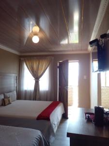 LeribeMonokotsoaing Guest House的酒店客房设有两张床和电视。