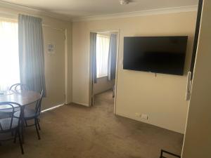 卡尔古利阿尔比欧酒店的一间房间,墙上设有一张桌子和一台电视机