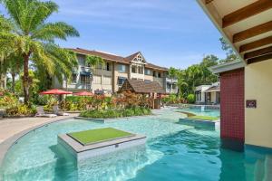 Cairns NorthThe Nest Cairns - 4 pools BBQ & Resort的棕榈树别墅内的游泳池