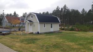 胡迪克斯瓦尔Charmigt hus och mysigt boende!的院子中一座黑色屋顶的小房子
