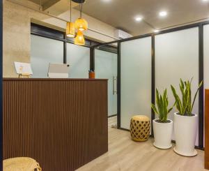 阿伯来Etereo Stays, Luxury Premium Apartments, Arpora, Goa的办公室,设有接待台和盆栽植物