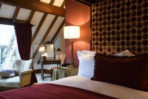 威尔汉姆普里奥里酒店的一间卧室配有一张带灯和椅子的床