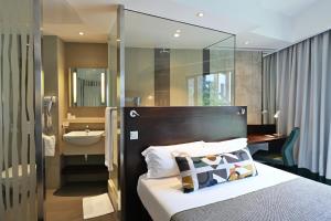 Moka瓦拉巴嘎迢勒酒店的一间卧室配有一张床,浴室设有水槽