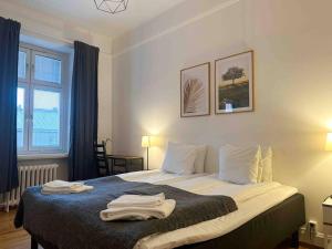 斯德哥尔摩Stay Inn Apartments Norrmalm的一间卧室配有一张床,上面有两条毛巾