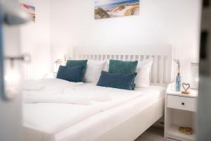 诺伊霍夫Haus am Buchenpark Remise 19的客房内的白色沙发,配有蓝色枕头