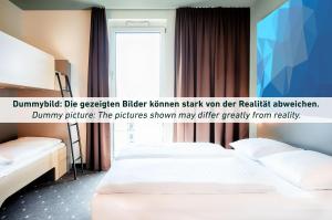 哈莱因附近普赫B&B HOTEL Salzburg-Süd的酒店客房设有两张床和窗户。