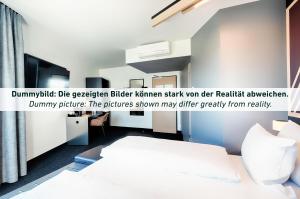 卡塞尔B&B HOTEL Kassel-Industriepark的一间卧室,配有一张床和一个读取假虎灯的标志