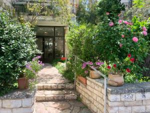 耶路撒冷Annie's Boutique Apartment in Jerusalem的一座花园,在一座建筑前种有鲜花和植物