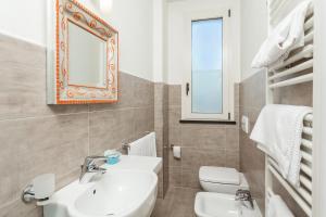 里米尼克里斯塔罗酒店的一间带水槽、卫生间和镜子的浴室