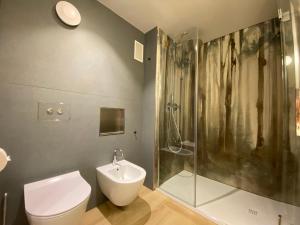 奥斯塔Sui Generis - Aosta Urban Apartments的带淋浴、卫生间和盥洗盆的浴室