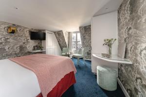 巴黎Hôtel Bourgogne & Montana的酒店客房带一张床、一张桌子和椅子