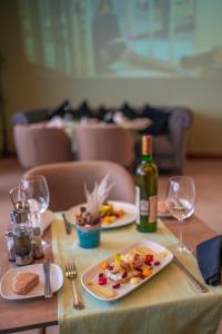 卡萨布兰卡肯兹巴斯马酒店的一张桌子,上面放着两盘食物和一瓶葡萄酒