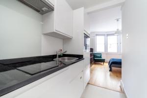 伦敦Cannon Street Studios的厨房配有白色橱柜和水槽