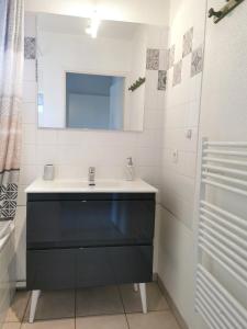 比斯卡罗斯海滩BiscaOcéan的浴室设有黑色水槽和镜子