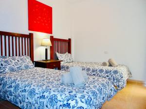 罗萨里奥港Brisa Del Mar Fuerteventura的一间卧室配有两张带蓝白色床单的床