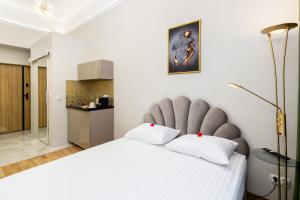 克拉科夫Jacuzzi Berka Apartamenty的卧室配有一张大白色的床和大床头板