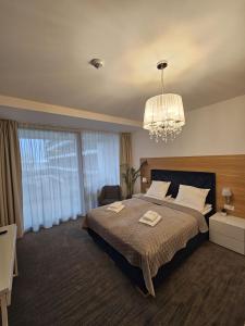 科沃布热格NCM Apartments Seaside Park的一间卧室配有一张大床和一个吊灯。