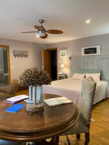 圣艾米隆尚布欧维莱酒店的客厅配有一张床和一张桌子及四柱床