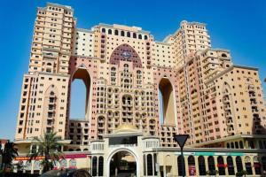 迪拜Manzil - Studio Apartment in Dubai Silicon Oasis near Dubai Outlet Mall的一座大建筑,前面有一个钟