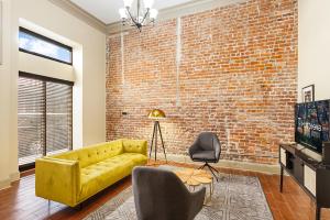 新奥尔良Chuck's Place的客厅设有黄色沙发和砖墙