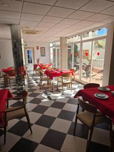 贝纳尔马德纳贝塔尼亚别墅酒店的餐厅设有红色的桌椅和 ⁇ 格地板